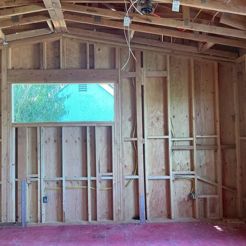Framed wall with a window and yellow NM cable during a remodel in Irvine