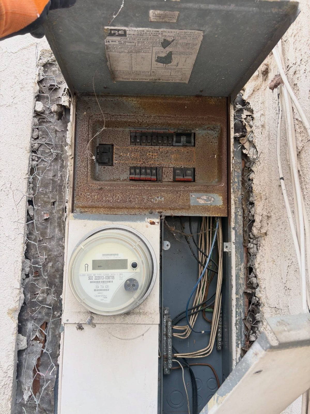 Old rusted meter and panel with exposed wires