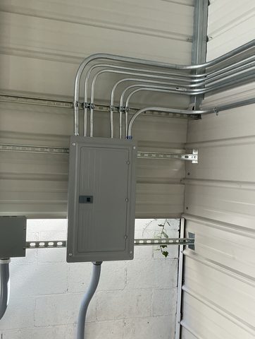 New closed panel with EMT conduit bends on a metal building wall